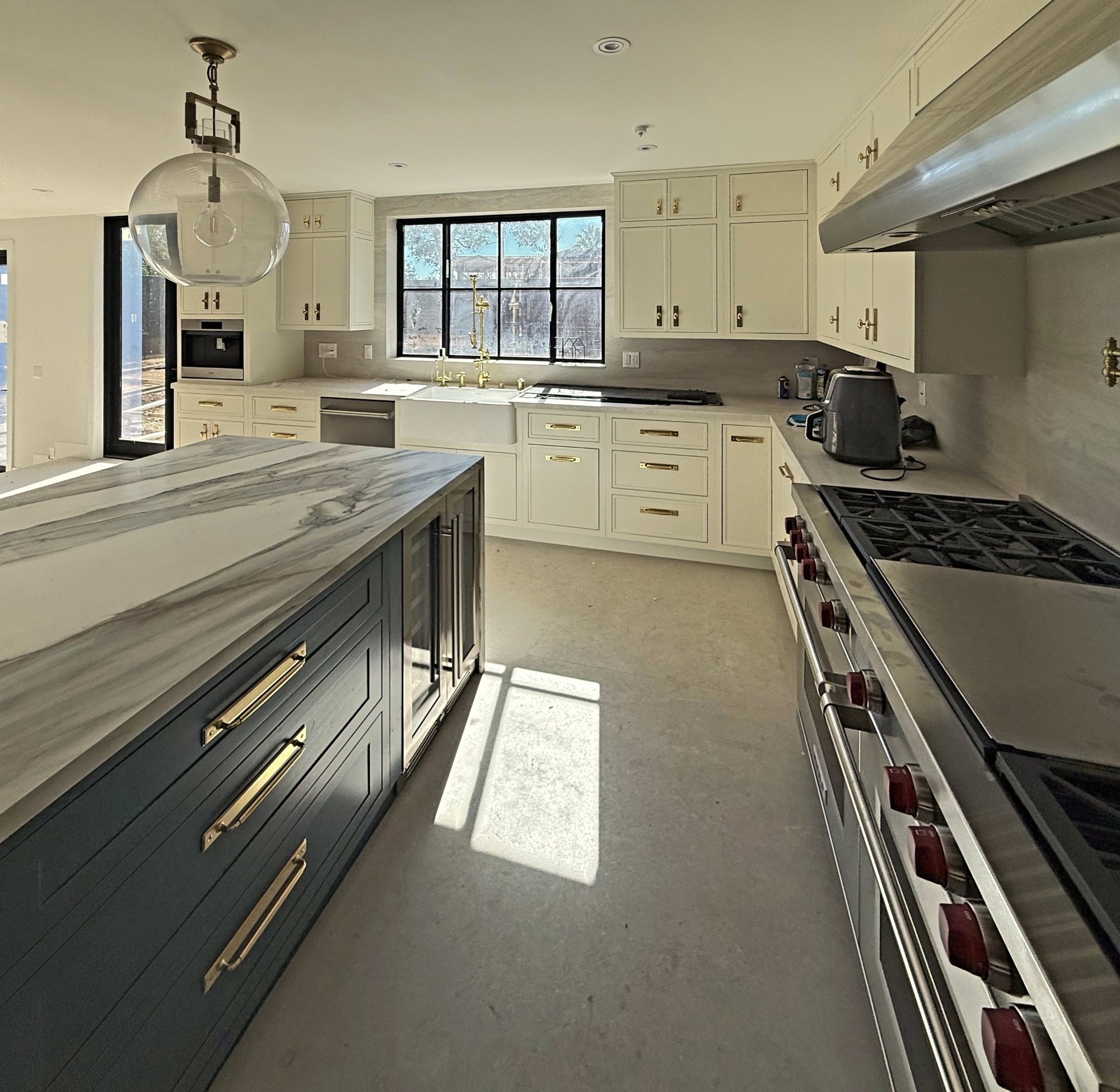 Kitchen with navy island and waterfall marble top